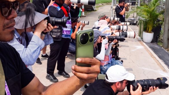 HONOR Magic9 Pro Max held beside photographers with telephoto cameras in HONOR's Sepang press image